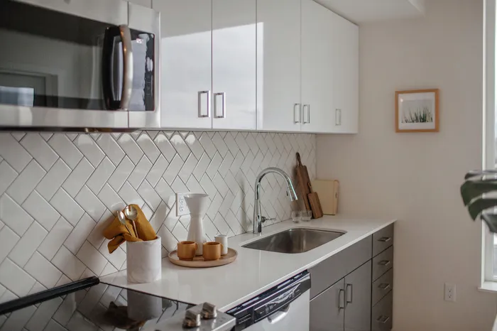 Kitchen with stainless-steel appliances, quartz countertops and subway tile backsplash