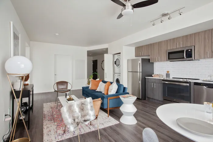 Living room and kitchen area with open-concept floorplan, luxury plank flooring and stainless steel appliances