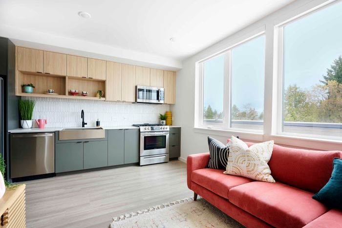open kitchen with stainless steel appliances and vinyl wood like flooring at novus woodstock apartments