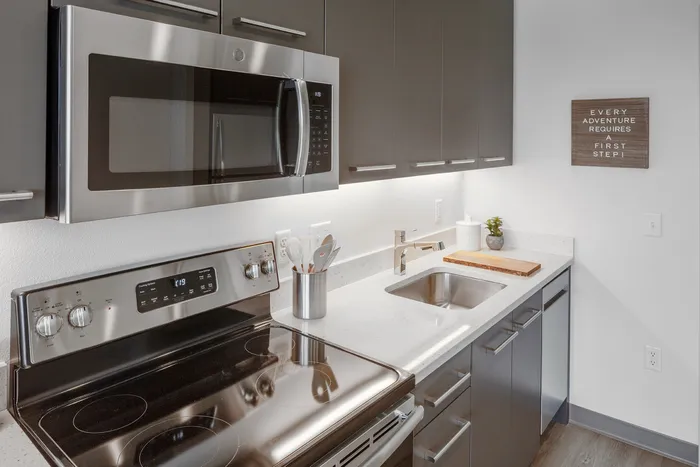 kitchen with stainless steel appliances and vinyl wood like flooring at aniva apartments