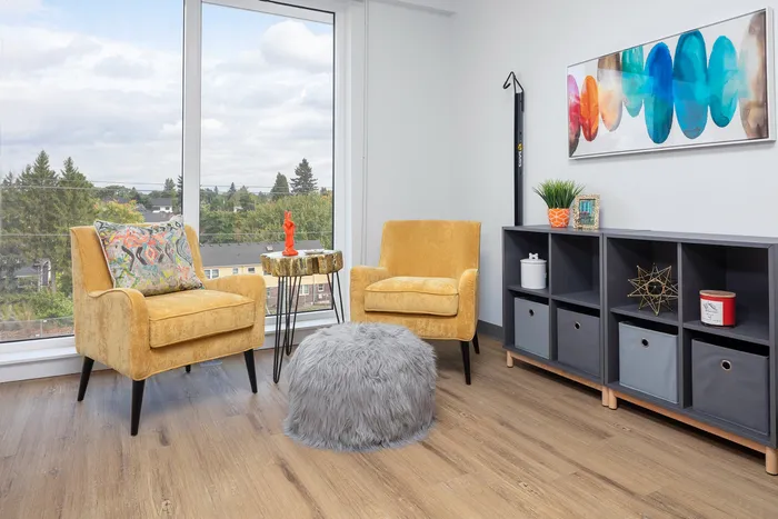 living room area with arm chairs and entertainment console at aniva apartments