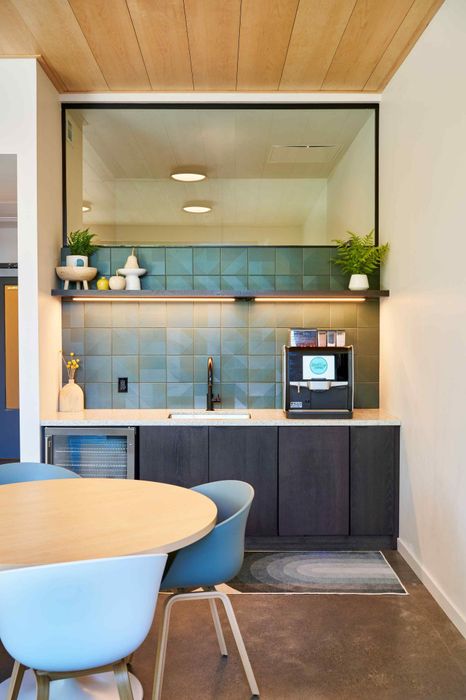 Apartments in Woodstock, OR - Novus - Coffee Station with Coffee Maker, Seating Area, and Mini Refrigerator
