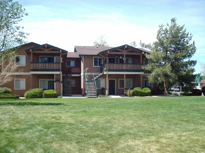 two story apartment building with grassy area in front at brooktree apartments