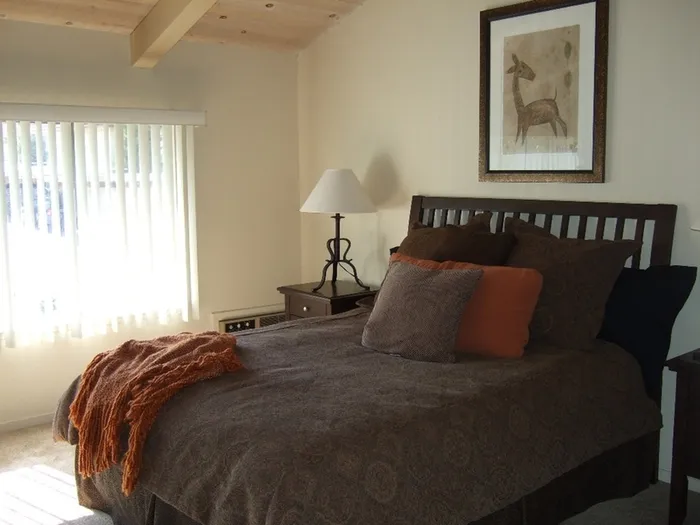 bedroom with bed and side tables and accent pillows at plumas garden apartments