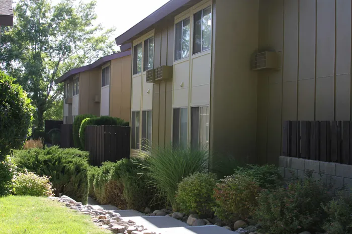 walkway in between grassy area and two story apartment building at plumas garden apartments