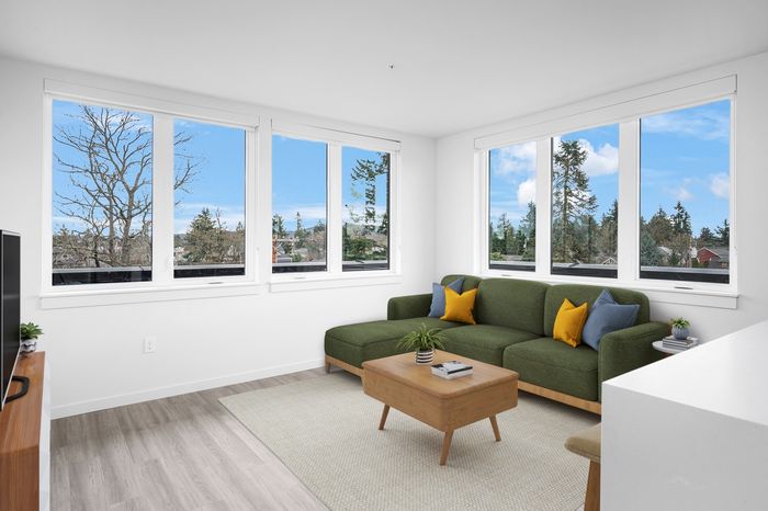 Apartments for Rent in Portland, OR - Novus - Living Room with Spacious Windows, Wood-Style Floors, and Green Couch