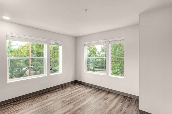 living area with large windows, wood-style plank flooring.