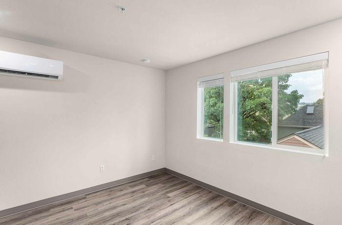 living area with large windows, wood-style plank flooring.