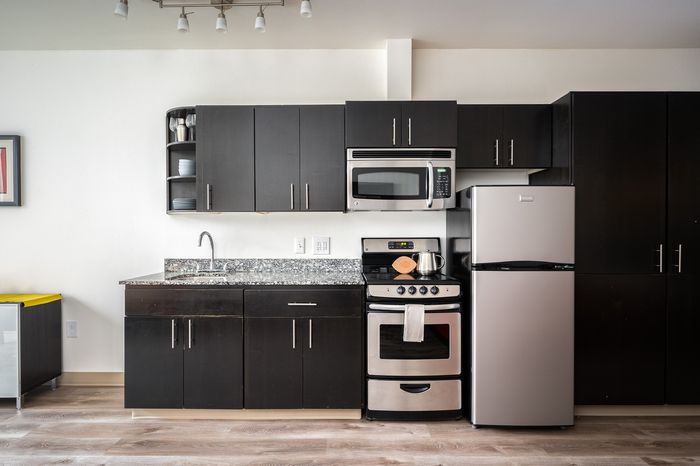 staged kitchen at milano featuring espresso cabinets and stainless steel appliances