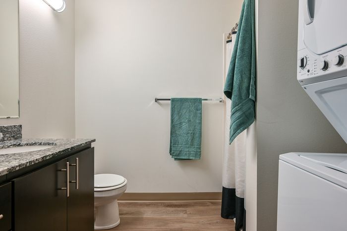 Bathroom in a studio apartment at Milano in Portland Oregon featuring a stackable in home washer and dryer
