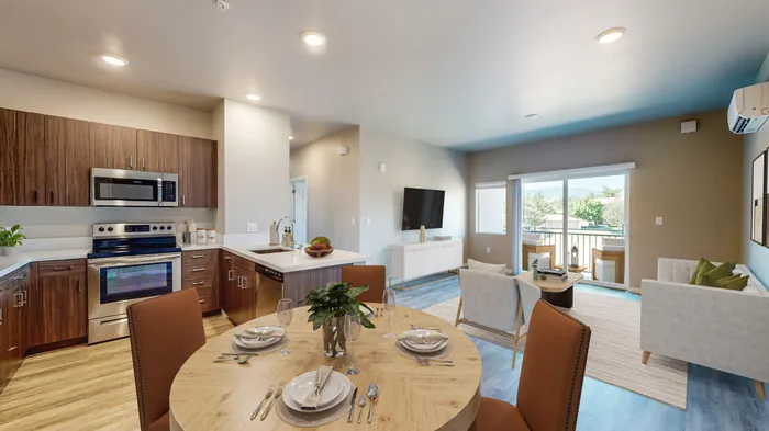 Pet-Friendly Apartments in Reno, NV - Canyon's Edge Apartments - Kitchen With Wooden Cabinets, Stainless Steel Appliances, Round Dining Table Set, and White Sofa.