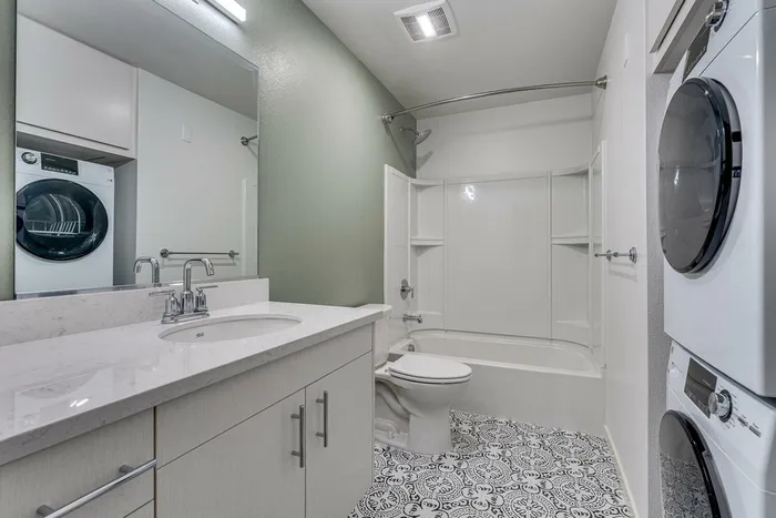 full bathroom with shower-tub combo and stacked washer and dryer at oner midtown