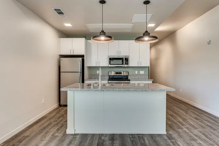 open kitchen with stainless steel appliances and floor to ceiling windows and patio door at oner midtown