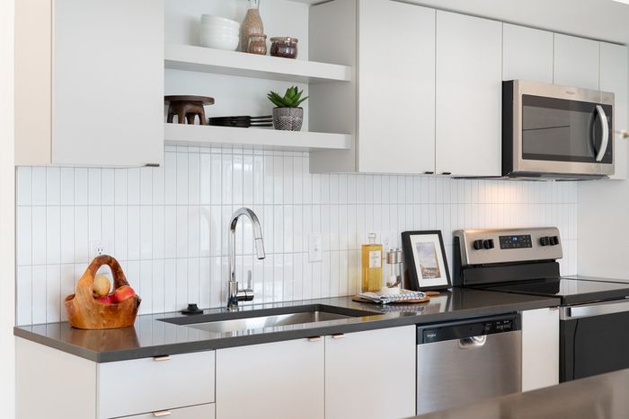 kitchen with quartz counters and tile backsplash and stainless steel appliances