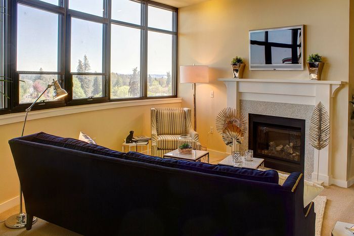 living room with blue suede sofa and arm chair next to gas fireplace