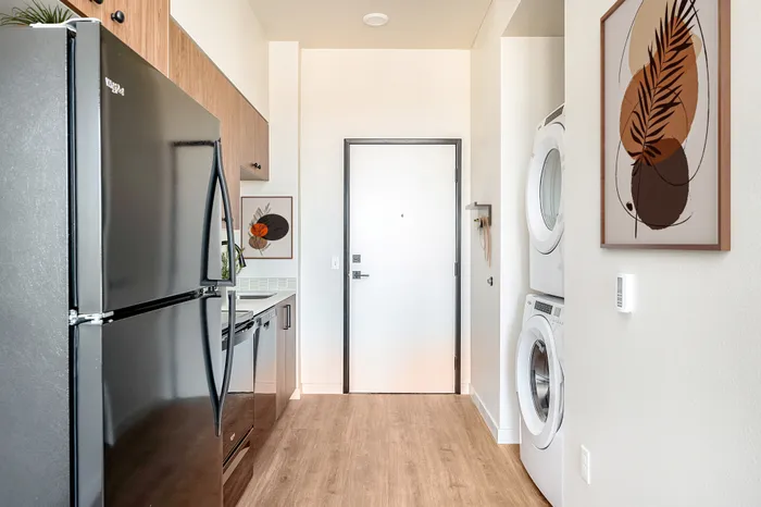 Kitchen and entrance area featuring a stackable in-home washer and dryer