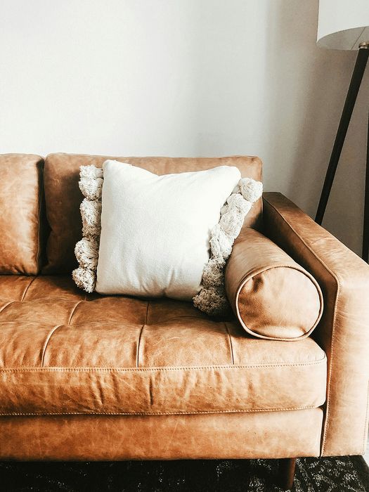 leather sofa with a white accent pillow in the corner