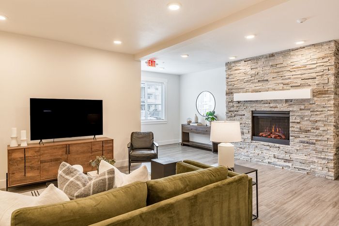 sofa and tv with a fire place nearby at the Clubhouse at Fernhill