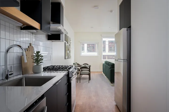Portland OR Studios for Rent - Jute - Modern Ktichen with Stainless Steel Appliances, White Tile Backsplash, and Matte Black Cabinetryvirtual staged living room and kitchen