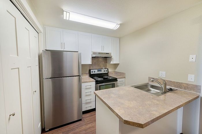 kitchen with faux hardwood flooring and stainless steel appliances at Quad apartments