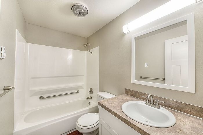 full shower-tub combo and faux wood flooring at quad apartments