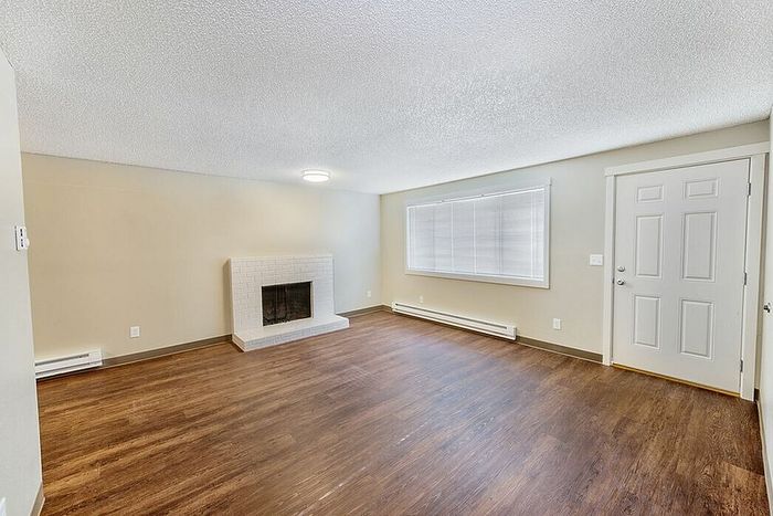 living room with fireplace and faux wood flooring at quad apartments