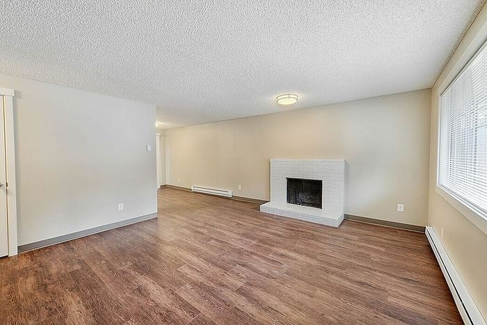 living room with fireplace and faux wood flooring at quad apartments