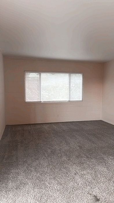 Carpeted bedroom with large windows