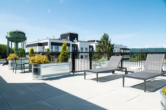 rooftop deck with lounge chairs, bbq grills, seating areas and panoramic portland, OR views