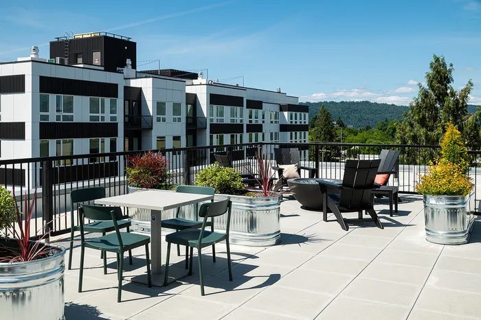 rooftop deck with lounge chairs, bbq grills, seating areas and panoramic portland, OR views