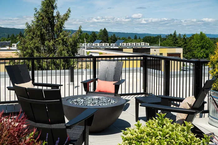 rooftop deck with lounge chairs, bbq grills, seating areas and panoramic portland, OR views