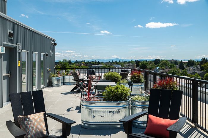 rooftop deck with lounge chairs, bbq grills, seating areas and panoramic portland, OR views