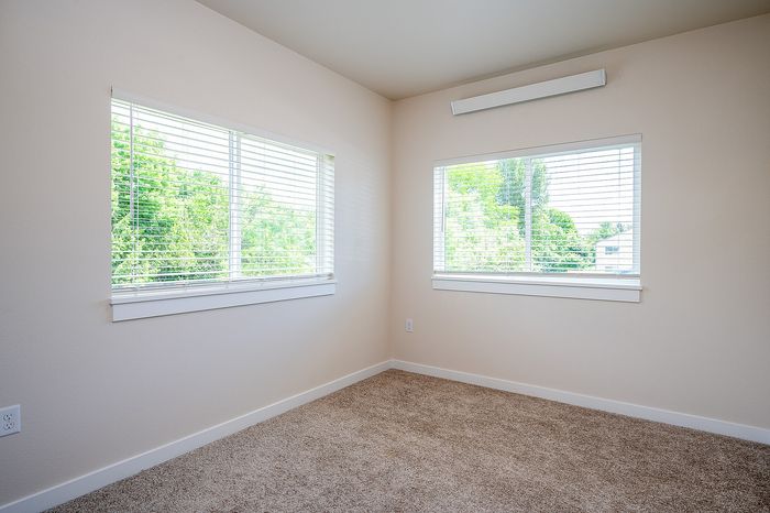 bedroom with large windows and carpeted flooring