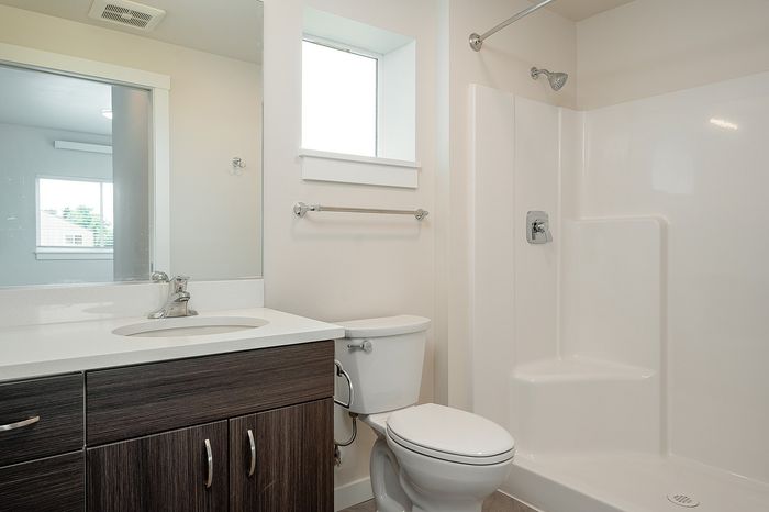 bathroom with toilet, sink, and shower