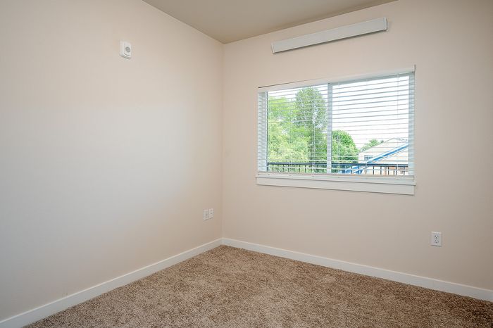 bedroom with large window and carpeted flooring
