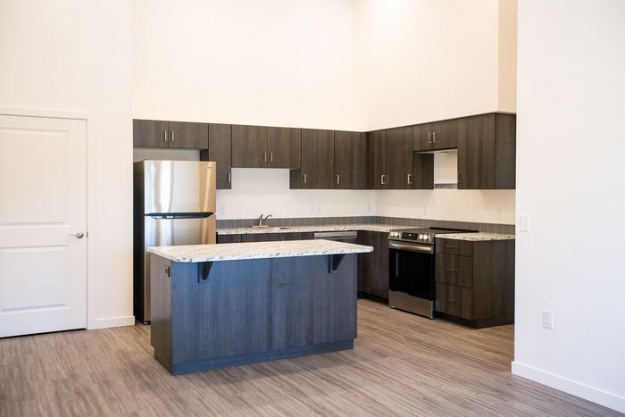 open kitchen with faux wood like flooring and stainless steel appliances at pacific ridge apartments