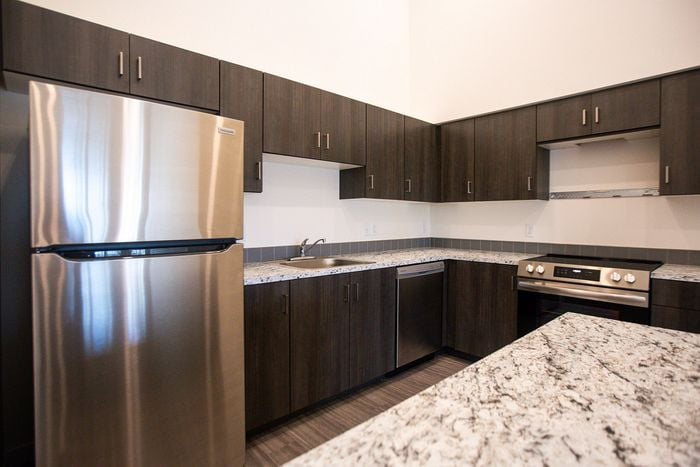 open kitchen with faux wood like flooring and stainless steel appliances at pacific ridge apartments