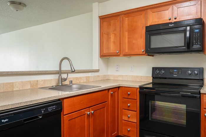 kitchen with wood cabinets and all black appliances