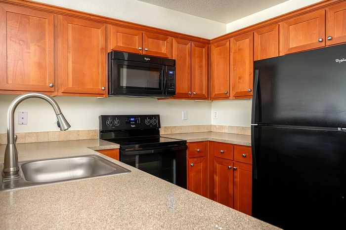 kitchen with wood cabinets and all black appliances