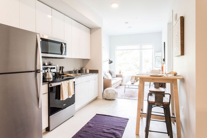 kitchen with stainless steel appliances and living room in the background