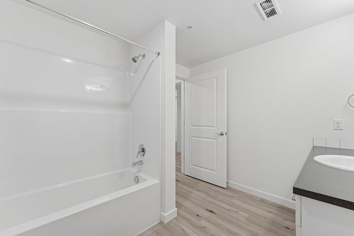 Bathroom with wood-style flooring and a shower/tub combo