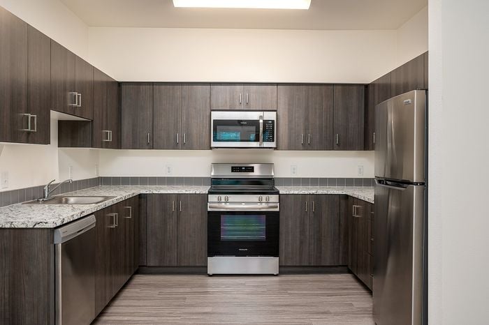 Kitchen at Pacific Ridge with dark cabinets light countertops, and stainless steel appliances