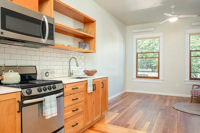 Kitchen and living area with original hardwood floors at Fairmount in Portland, OR