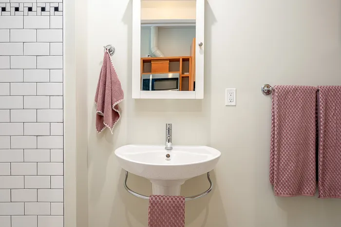 bathroom with shower and pedestal sink at Fairmount Apartments located in Portland, OR