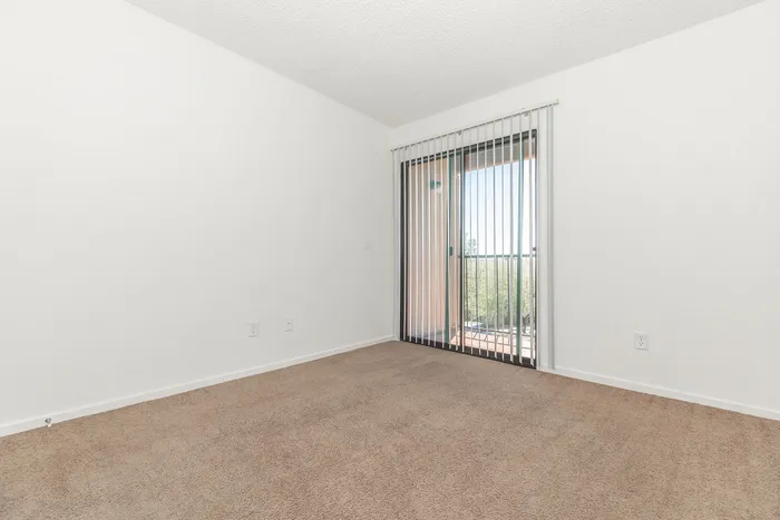 carpeted living with sliding glass door to patio/balcony