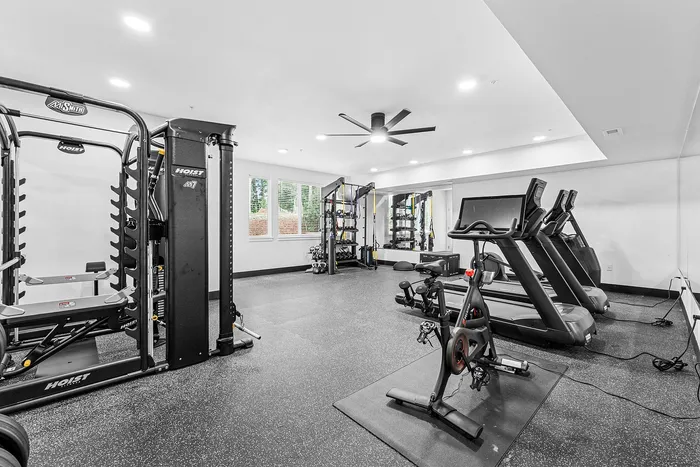 Newburg, OR, Apartments with EV Charging Station - Spring Meadow - Fitness Center With Treadmills, Stationary Bike, Strength Training Equipment, Rubber Flooring, And Large Ceiling Fan.