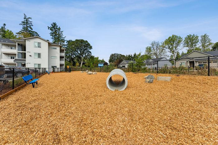 Apartments in Newburg, OR, with In-Unit Washer and Dryer - Spring Meadow - Fenced Dog Park With Wood Chip Ground, Concrete Agility Tunnel, And Benches.