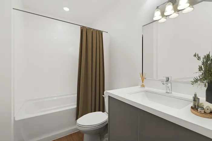 bathroom with bath and shower tub combo and large vanity mirror