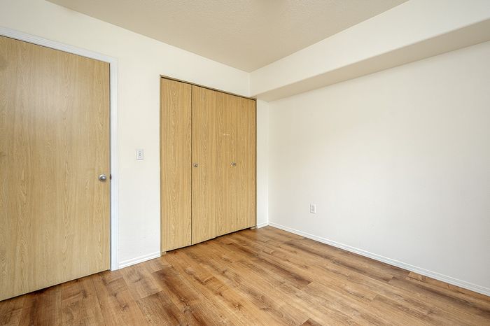 Bedroom with closet and wooden floor.