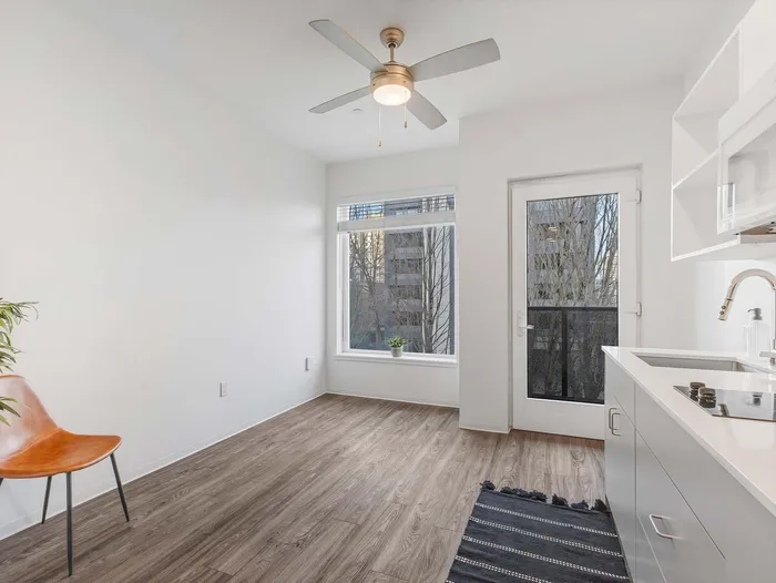 Bright studio living area with hardwood-style flooring at Koz on 4th.